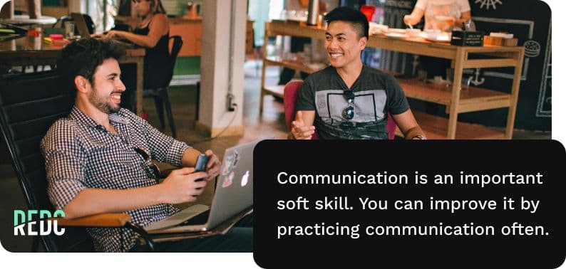 Image: two coworkers on laptops in the living room of someone's house. They're laughing at their computers while people are eating and fixing dinner in the background. Text: Communication is an important soft skill. YOu can improve it by practicing communication often.