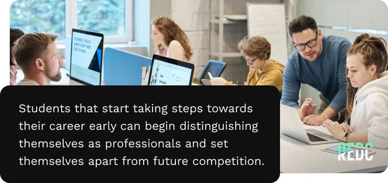 Students working at desktops and laptops with an instructor assisting.