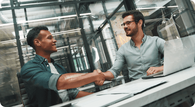 A supervisor and new hire shake hands. 