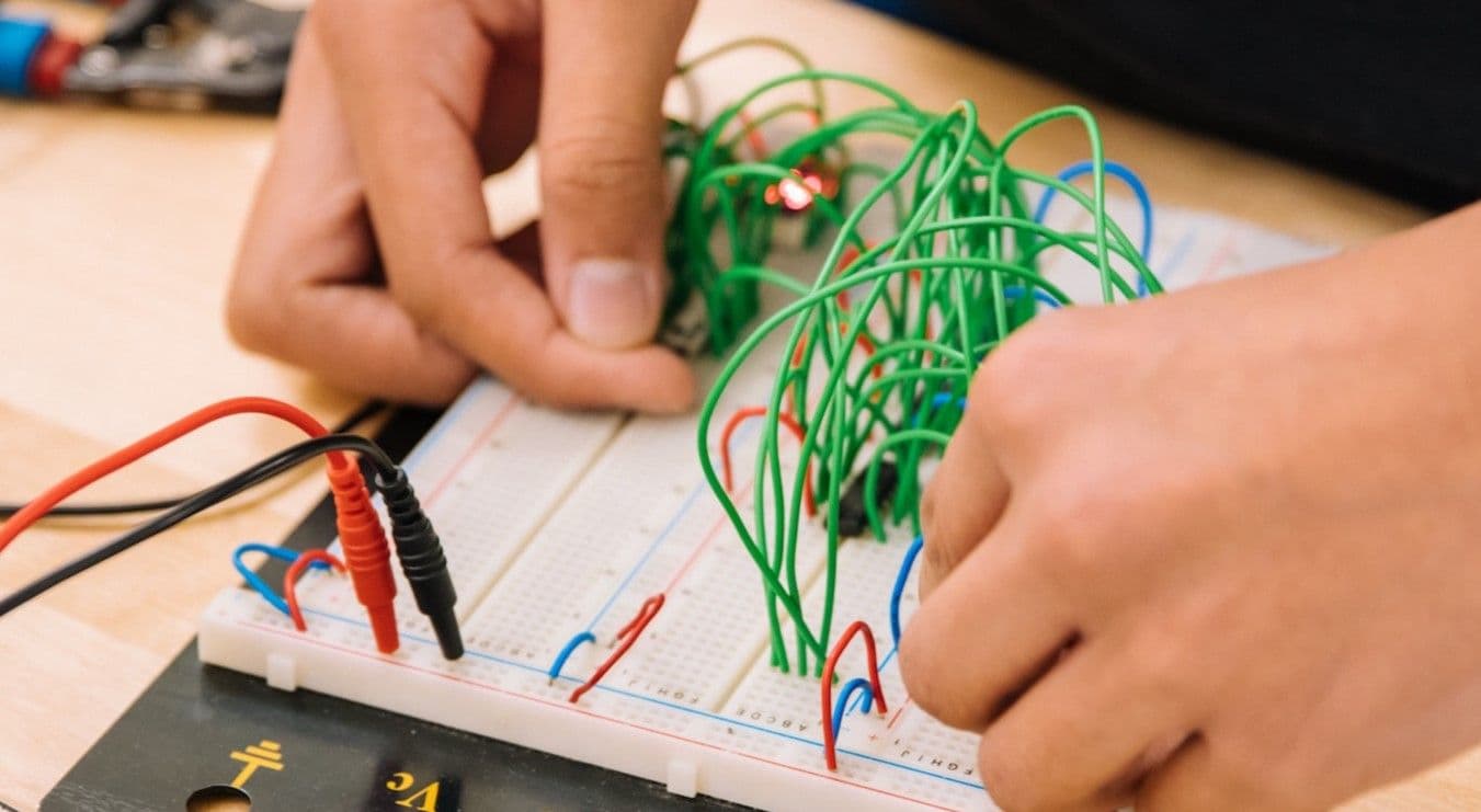Person learning how to wire a circuit board