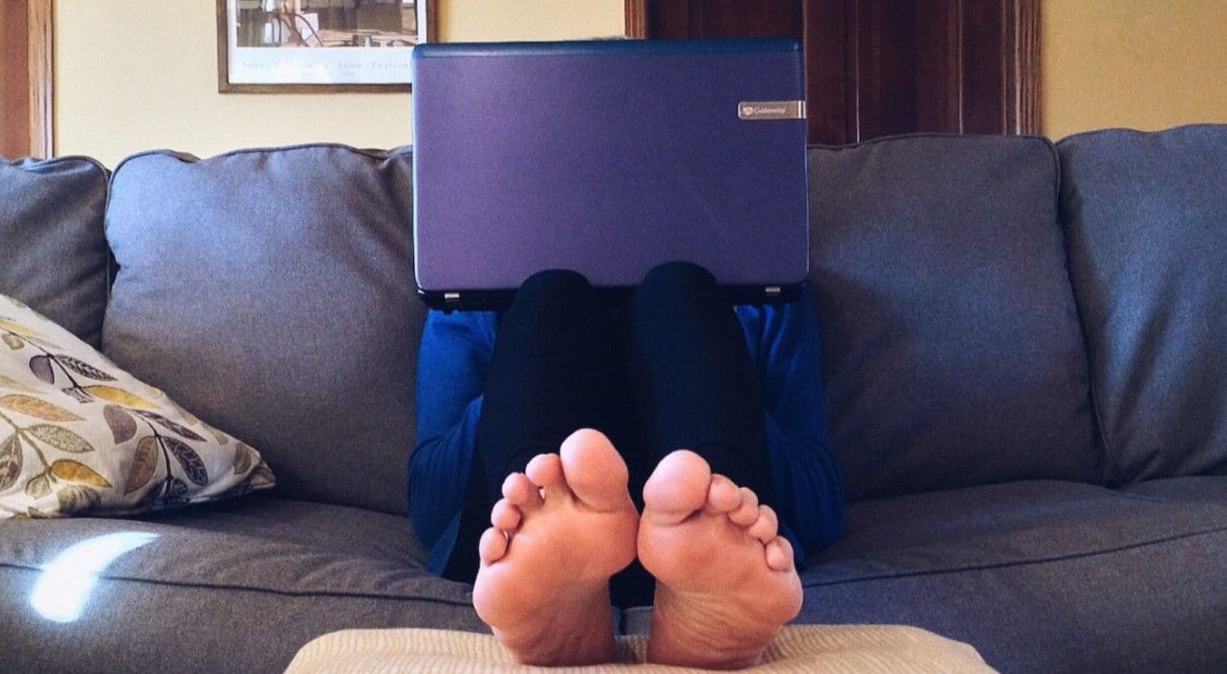 Person working from home sitting on couch with feet up