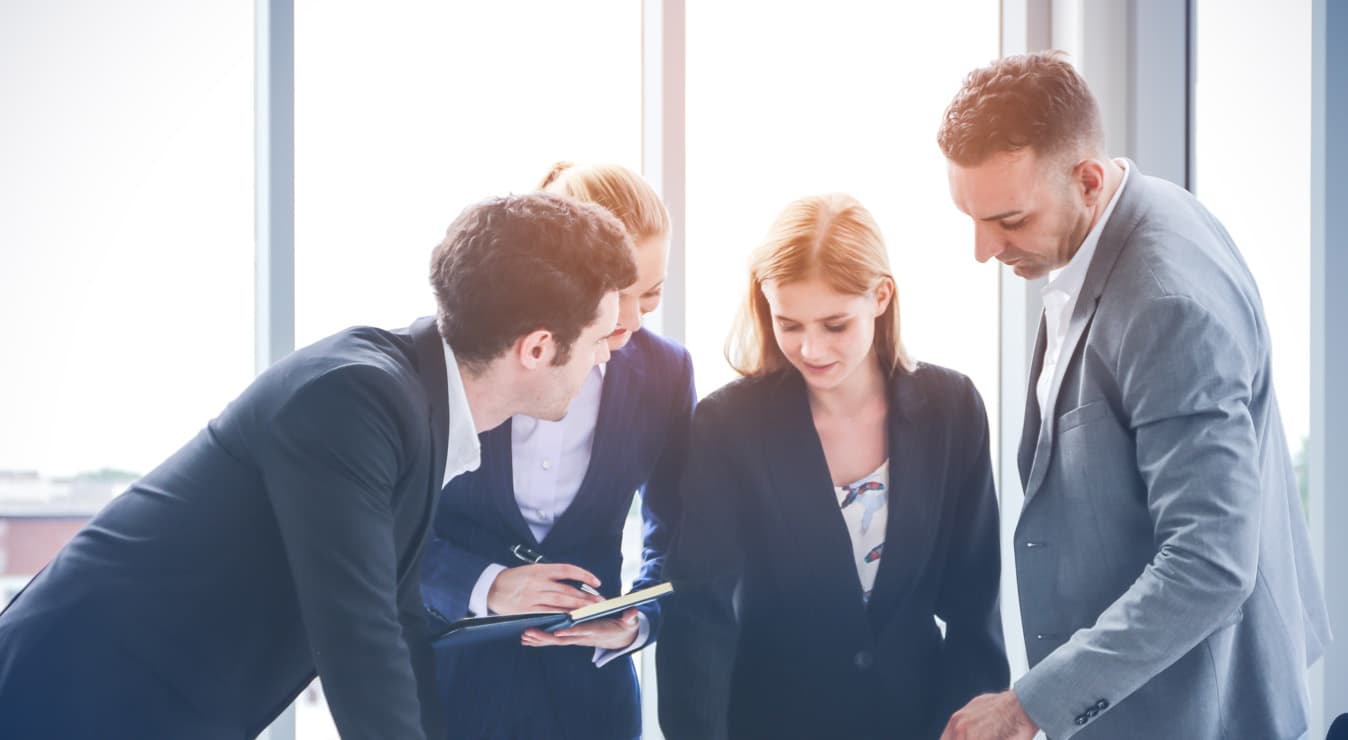 A group of professionals collaborating in a corporate setting, engaged in productive work and teamwork to achieve business goals.