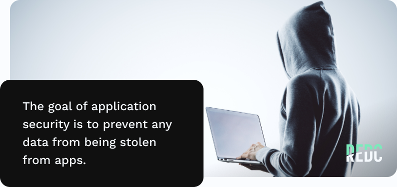 A mysterious-looking figure in a hoodie facing a computer screen.